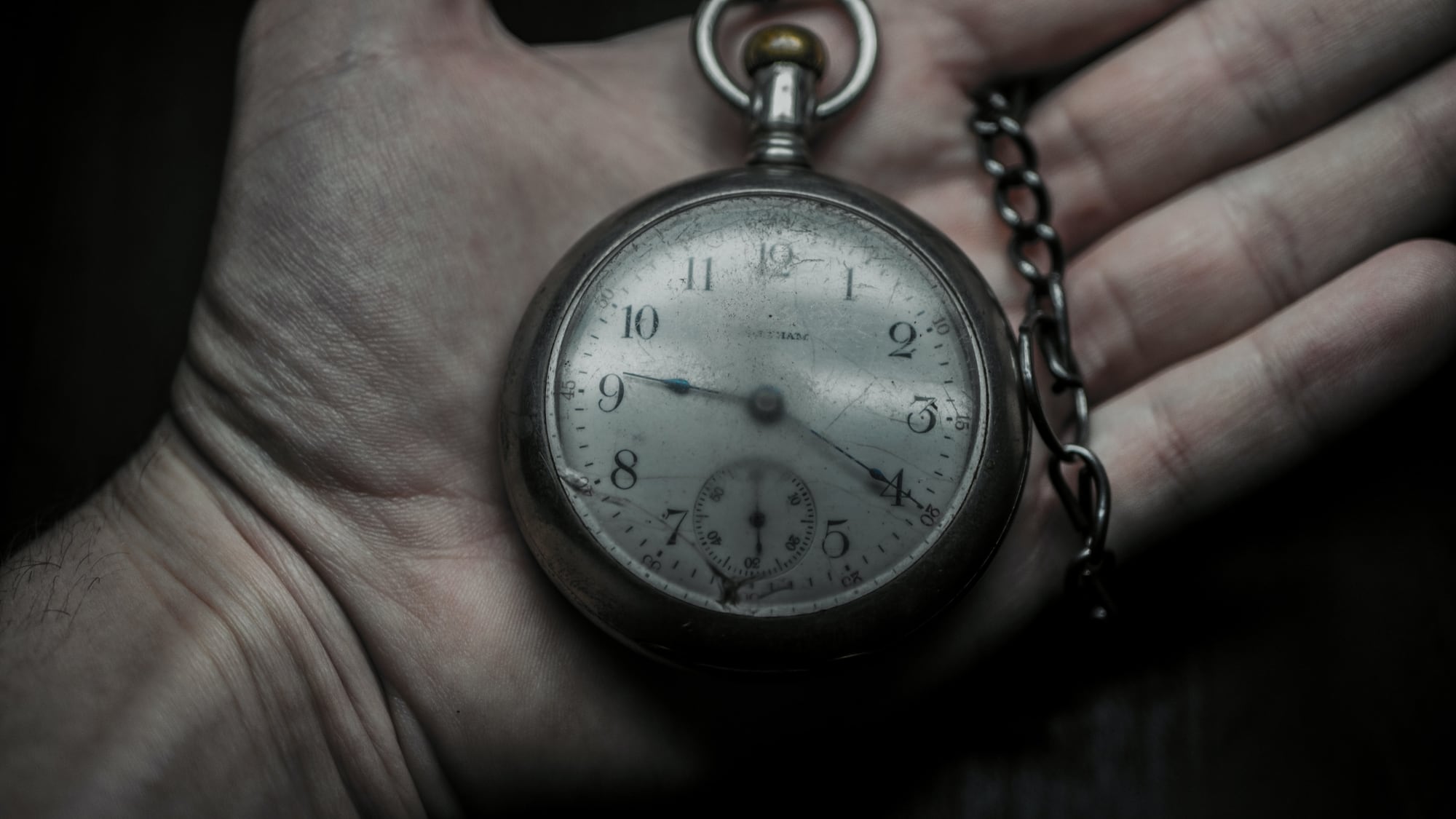 Hand holding old pocket watch.